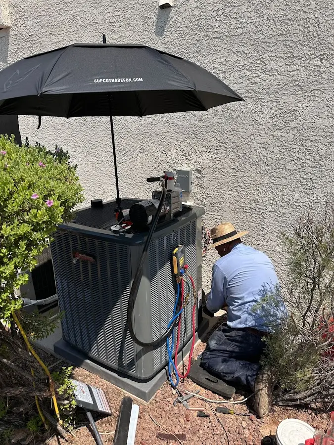 HVAC technician performing outdoor AC maintenance in Hockessin